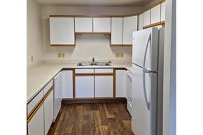 Iowa Falls apartment for rent - A kitchen with white cabinets and a white refrigerator.