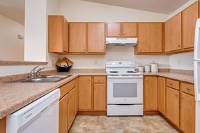 Neenah apartment for rent - A kitchen with wooden cabinets and a white dishwasher.