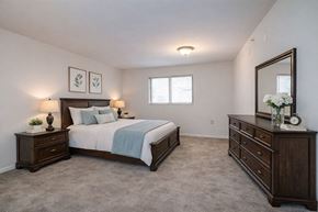 Alliance apartment for rent - A bedroom with a bed, dresser, and mirror.