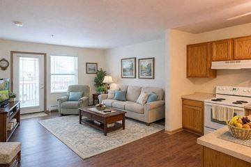 Milwaukee apartment for rent - A living room with a couch, chair, and a table with a basket of fruit on it.