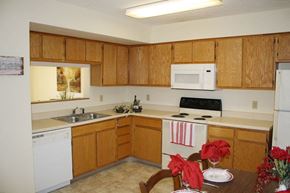 Clear Lake apartment for rent - a kitchen with white appliances and wooden cabinets