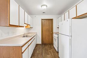 Lawrence apartment for rent - A kitchen with white appliances and wooden cabinets.