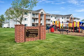 Chanute apartment for rent - A sign for Cornerstone Apartments is in front of apartment buildings.