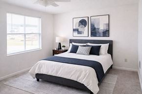Hopkinsville apartment for rent - A bedroom with a bed, nightstand, and two framed pictures on the wall.