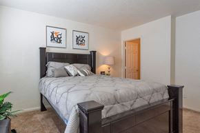Garden City apartment for rent - A bedroom with a large bed and two framed pictures on the wall.