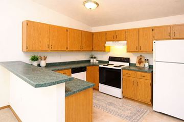 Sturgeon Bay apartment for rent - A kitchen with wooden cabinets and a green counter top.