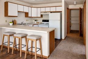 Grundy Center apartment for rent - A kitchen with white appliances and wooden cabinets.
