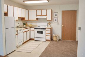 Hays apartment for rent - A kitchen with white appliances and wooden cabinets.