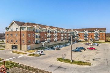 Ames apartment for rent - A large apartment complex with a parking lot in front.