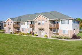 Milton apartment for rent - a brick apartment building with a green lawn