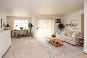 Sturgeon Bay apartment for rent - A living room with a couch, chair, and potted plants.