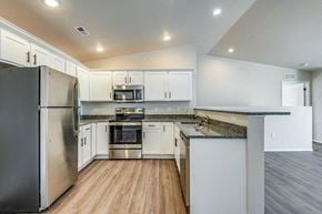 Sturgeon Bay apartment for rent - a kitchen with white cabinets and stainless steel appliances