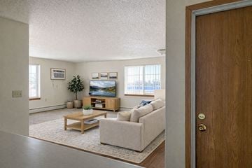 Grundy Center apartment for rent - A living room with a couch, coffee table, and a painting on the wall.