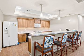 Decatur apartment for rent - A kitchen with a white fridge and wooden cabinets.