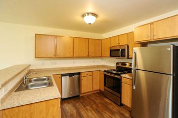 Kiel apartment for rent - a kitchen with stainless steel appliances and wooden cabinets