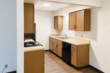 Newton apartment for rent - A kitchen with wooden cabinets and a black stove top.