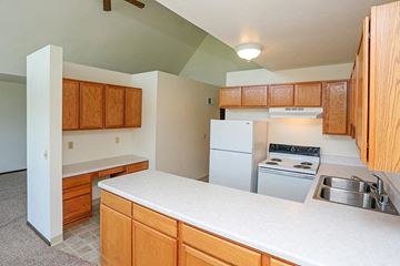 Hartland apartment for rent - A kitchen with white countertops and wooden cabinets.