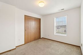 Lawrence apartment for rent - A room with a brown door and a window with a view of a fence and trees.