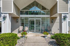 Stevens Point apartment for rent - the front entrance of a building with a patio and chairs