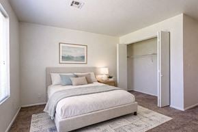 Liberal apartment for rent - A bedroom with a bed, a lamp, and a painting on the wall.