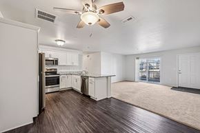 New Richmond apartment for rent - A spacious kitchen with white cabinets and a ceiling fan.