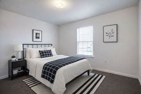 Tulsa apartment for rent - A bedroom with a bed, nightstand, and two pictures on the wall.
