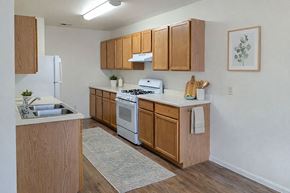 Rifle apartment for rent - A kitchen with wooden cabinets and a white stove top oven.