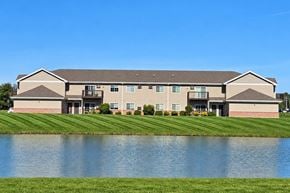 Kiel apartment for rent - A large building with a grey roof and a pond in front.