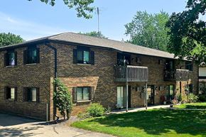 Shawano apartment for rent - A brick building with a green lawn in front.