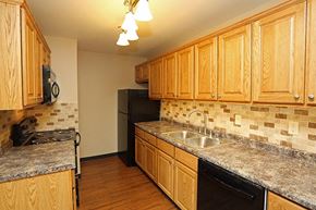 La Crosse apartment for rent - A kitchen with wooden cabinets and granite countertops.