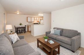 Hugoton apartment for rent - A living room with a grey couch, a wooden coffee table, and a lamp.
