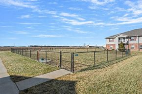 Chatham apartment for rent - A black fence surrounds a green field with a building in the background.
