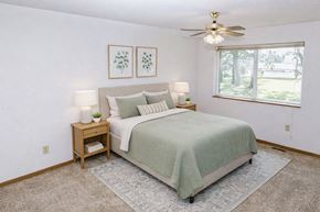 Waseca townhouse for rent - A bedroom with a bed, nightstand, and two framed pictures on the wall.