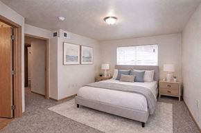 Fairmont apartment for rent - A bedroom with a bed, nightstands, and a rug.