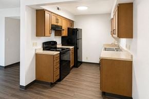 Newton apartment for rent - A kitchen with wooden cabinets and black appliances.