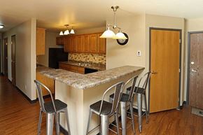 La Crosse apartment for rent - A kitchen with a granite counter top and bar stools.