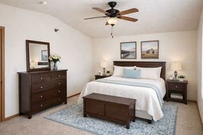 Osceola apartment for rent - A bedroom with a bed, dresser, and nightstand.