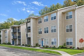 Fairmont apartment for rent - Apartment building with a blue door and a red tree in front.