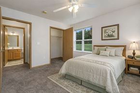 Oshkosh townhouse for rent - A bedroom with a large bed and a ceiling fan.