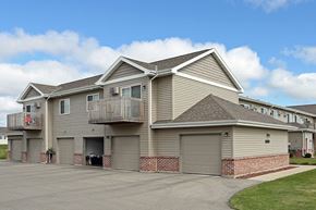 Ripon apartment for rent - a beige house with a balcony and garage doors