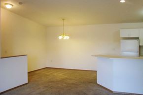 Manitowoc apartment for rent - an empty living room with a kitchen and a chandelier