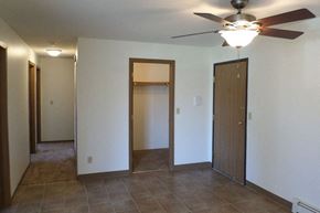 Albert Lea apartment for rent - an empty living room with a ceiling fan and a closet