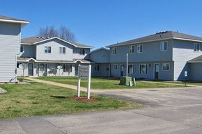 Zumbrota townhouse for rent - a row of houses with a sign in the grass