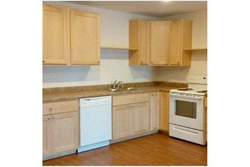 Viroqua apartment for rent - a kitchen with white appliances and wooden cabinets
