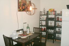 Atlantic apartment for rent - A dining room with a table, chairs, and a shelf with various items.