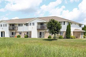 Kaukauna apartment for rent - A white apartment building with a green lawn in front.