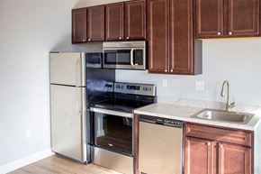 Charles City apartment for rent - a kitchen with stainless steel appliances and wooden cabinets