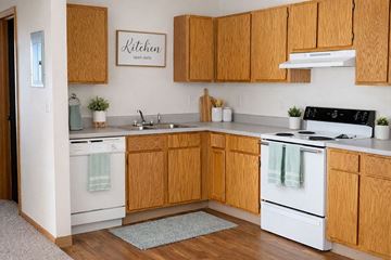 Osceola apartment for rent - A kitchen with wooden cabinets and a sign that says "Kitchen" on the wall.