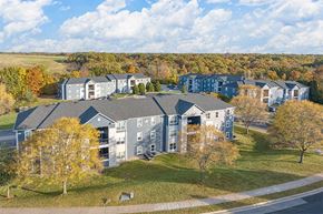 Peoria apartment for rent - an aerial view of an apartment building with trees and a grass field