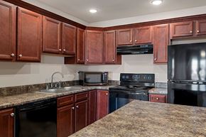 Chatham apartment for rent - A kitchen with brown cabinets and black appliances.